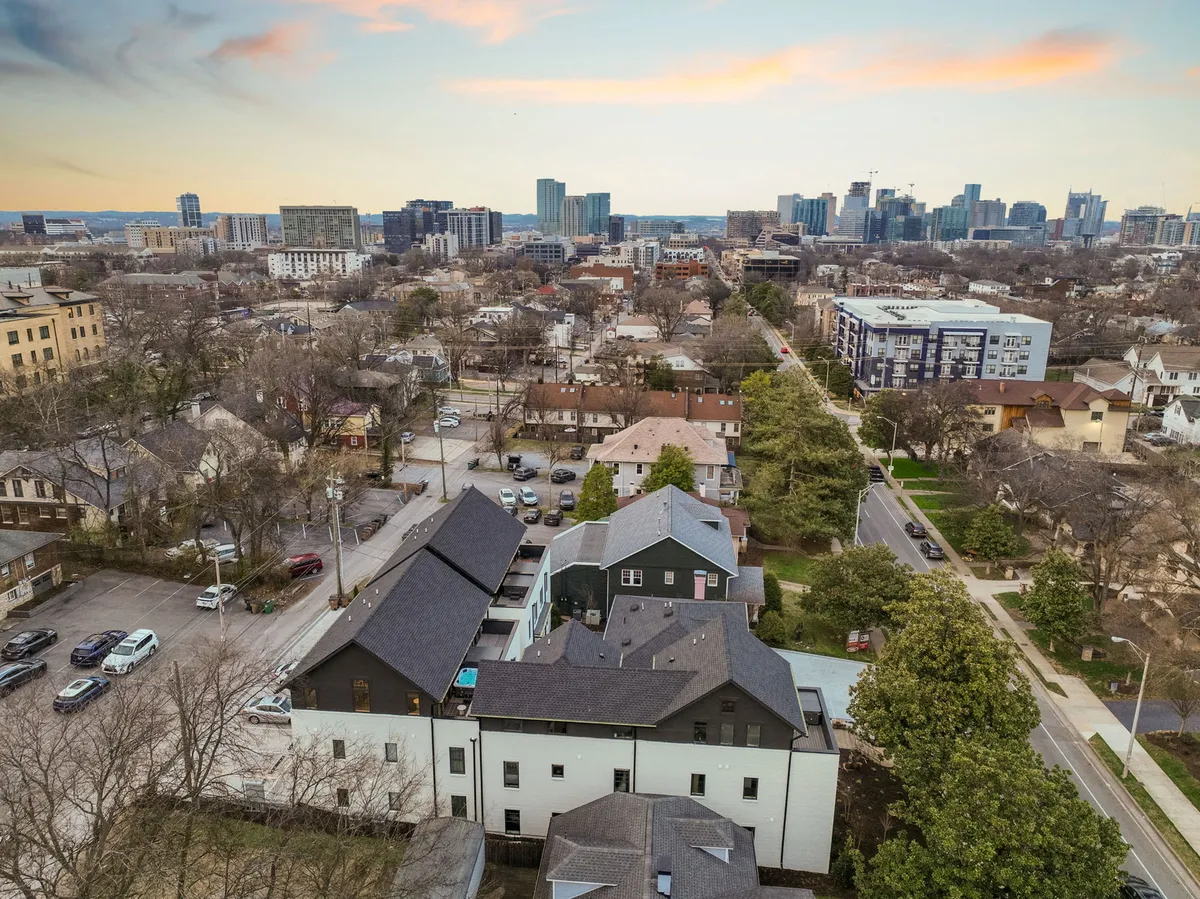 A wide view of the city skyline and tree-lined residential streets, capturing the urban vibrancy and accessibility of Nashville. The image highlights inviting streets perfect for walking, biking, and discovering neighborhood cafes or hidden gems.