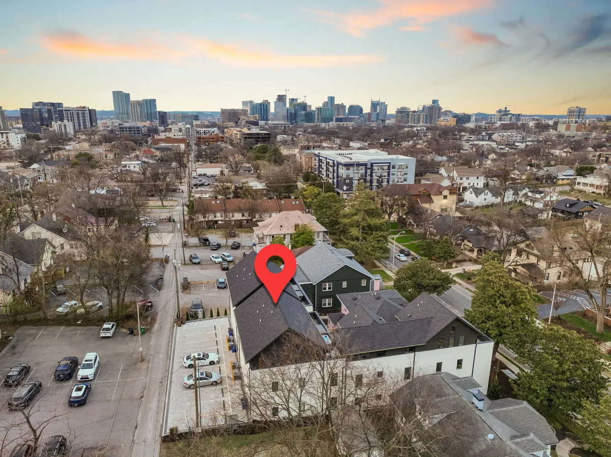 A wide-angle exterior view captures rooftops of nearby houses and Nashville's expansive skyline under open skies. The scene showcases the city's energy and the elevated perspective you might enjoy from a rooftop or balcony.